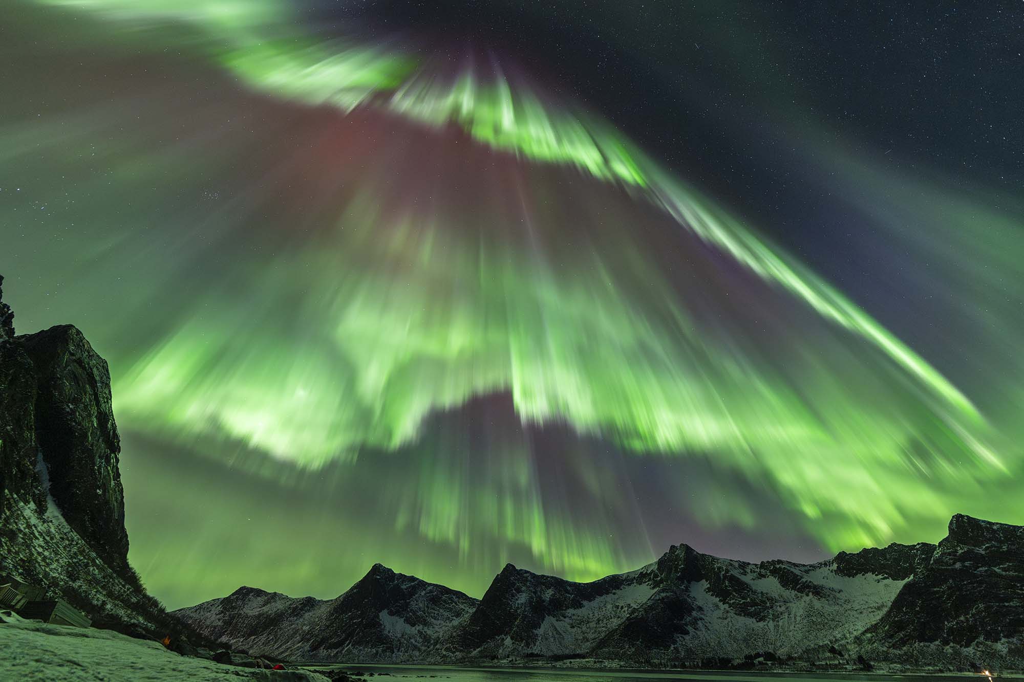 several northern lights curtains appear to be falling almost vertically from 